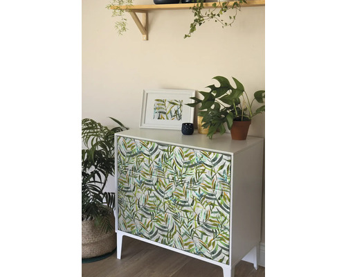 Commode met bladerdecoratie, aangevuld met kamerplanten en wanddecoratie