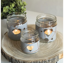 Decoratieve theelichthouders van glas met hartjesdesign op een houten schijf