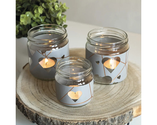 Decoratieve theelichthouders van glas met hartjesdesign op een houten schijf