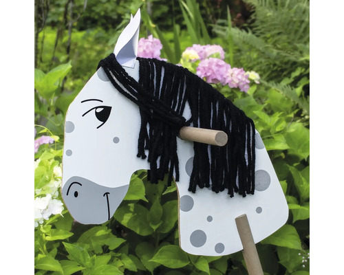 Houten hobbelpaard met manen van garen in de tuin