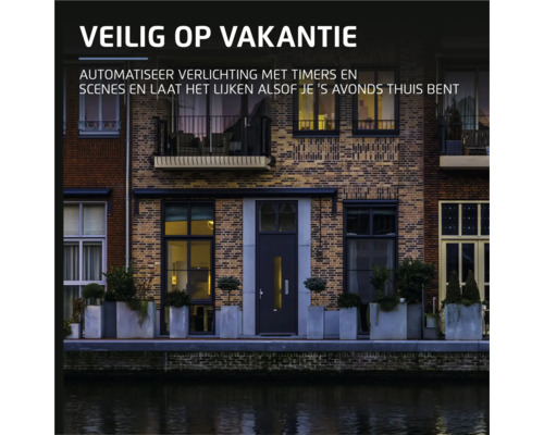 Gevel van een huis aan het water met de tekst: Veilig op vakantie. Automatiseer verlichting met timers en scenes en laat het lijken alsof je ''s avonds thuis bent.