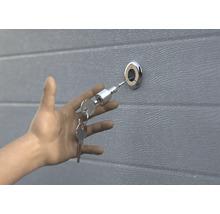 Hand opent garagedeur met sleutel