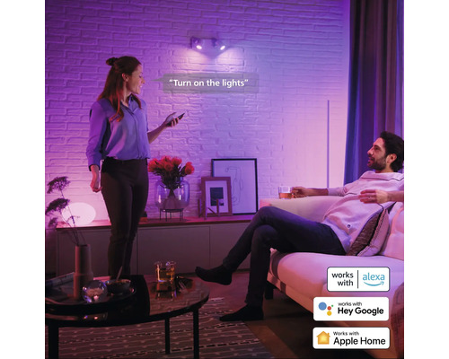 Woonkamer met twee personen die slimme verlichting met spraakbesturing gebruiken