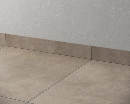 Vloertegels en keramische plinten tegen een muur