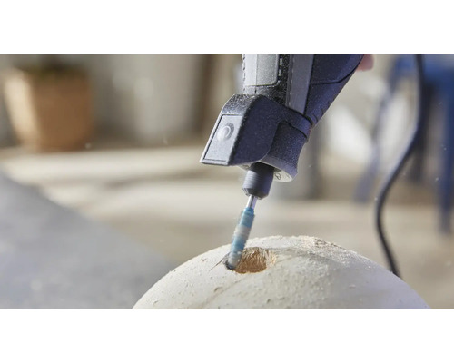 Een handboormachine boort een gat in een rond object.