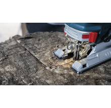 Close-up van een decoupeerzaag die isolatiemateriaal snijdt.