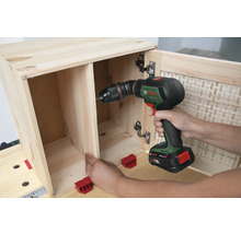 Iemand boort een houten meubel in elkaar met een accuschroefboormachine.