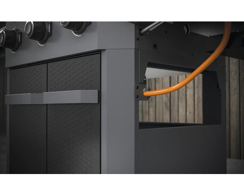 Detailopname van een gasbarbecue met kastelementen en gasleiding.