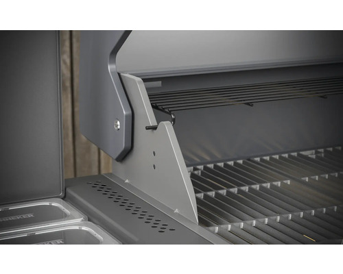 Detailopname van een open gasbarbecue met grillrooster en warmhoudrek