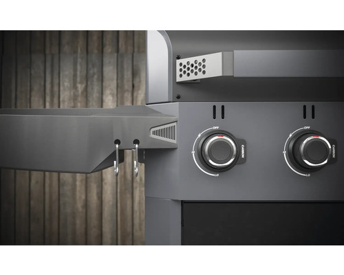 Detailopname van een houtskoolbarbecue met draaiknoppen en opbergruimte