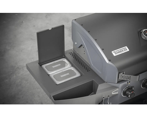 Detailaanzicht van een gasbarbecue met geopend warmhoudrek en het Tenneker logo.