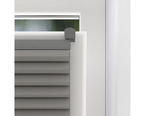 Gedetailleerde close-up van een grijs plisségordijn op een raam.