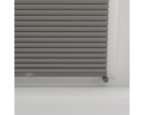 Grijs plisségordijn in het raam