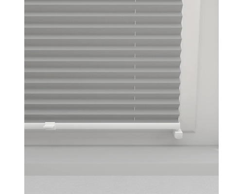 Grijze plisségordijnen op het raam