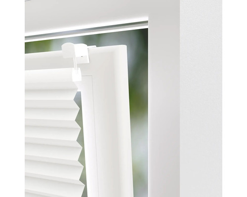 Close-up van een wit plisségordijn op een raam