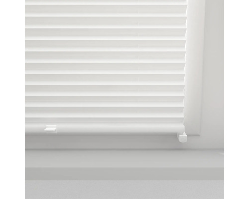 Close-up van een wit plisségordijn op een raam