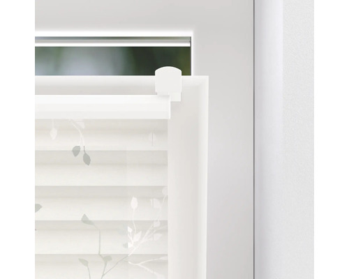 Detailopname van een rolgordijn met bladerenprint op het raam