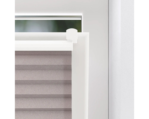 Detail van een plisségordijn op het raam