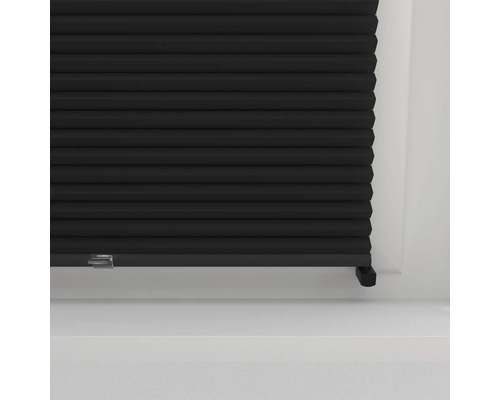 Close-up van een zwart plisségordijn voor een raam