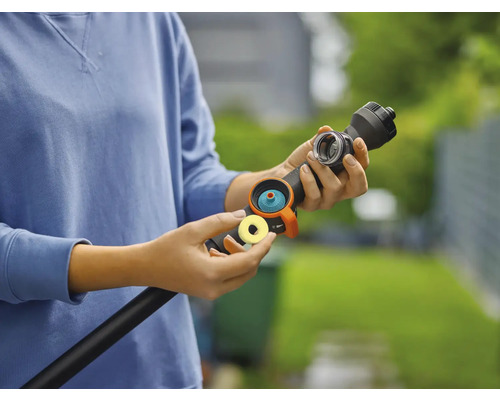 Een persoon verbindt een tuinslangkoppeling met een tuinslang
