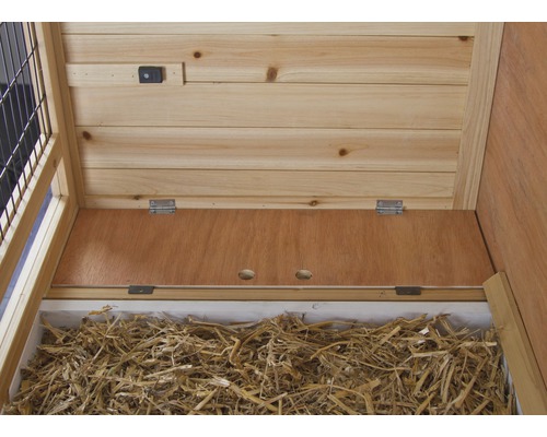 Interieur van een houten konijnenhok met hooi