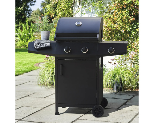 Zwarte gasbarbecue met drie branders, dekselthermometer en onderkast op een tuinterras.