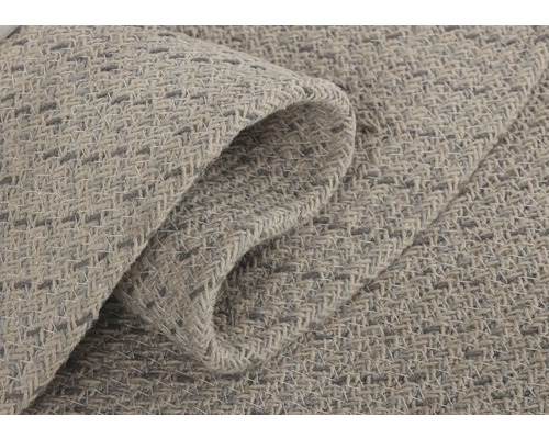 Close-up van een lichtgekleurd tapijt met geweven textuur