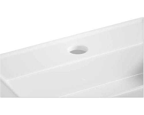 Detailopname van een witte wastafel met kraangat