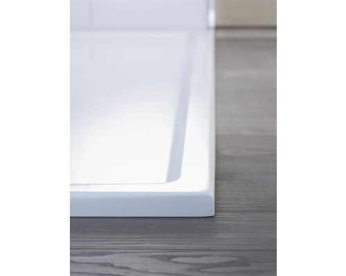 Detail van een douchebak op een houten vloer