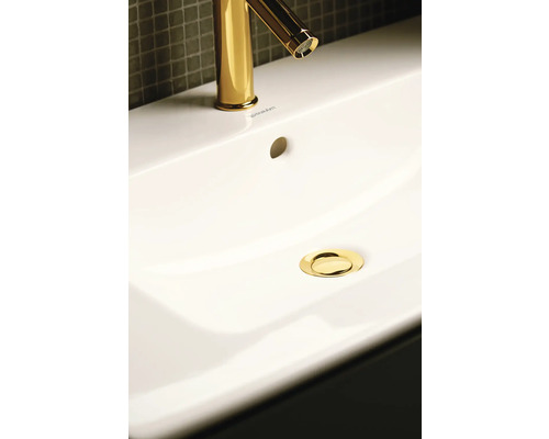 Afbeelding van een wastafel met goudkleurige kraan en afvoer