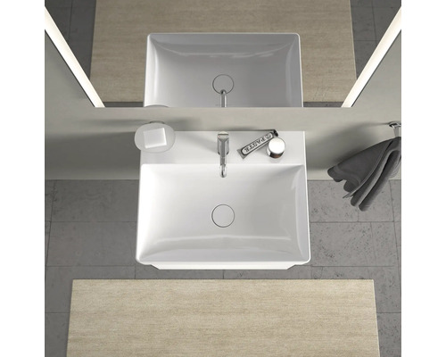 Bovenaanzicht van een badkamer met wastafel, zeep, handdoek en spiegel