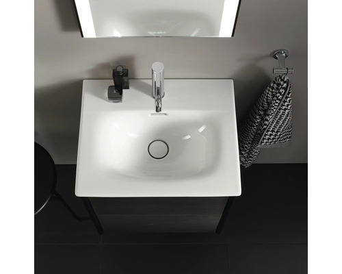 Bovenaanzicht van een badkamer wastafel met kraan, handdoek en spiegel