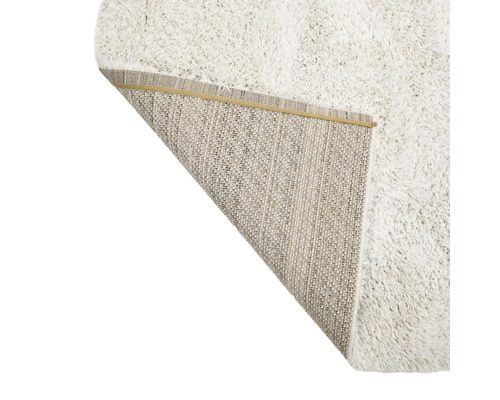 Zacht vloerkleed met omgeslagen hoek die de achterkant laat zien