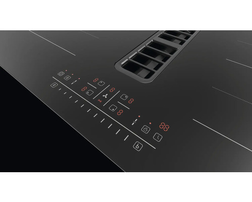 Detailopname van een zwarte inductiekookplaat met geïntegreerde afzuigkap