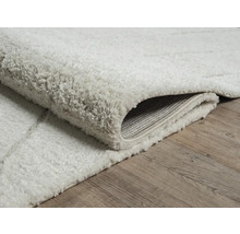 Zacht, lichtgekleurd vloerkleed met patroon op een houten vloer