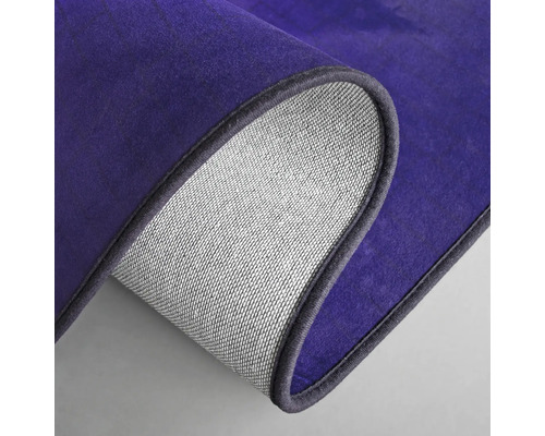 Detail van een paars tapijt met textielen achterkant