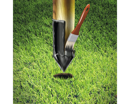 Paal met teercoating en penseel op gazon