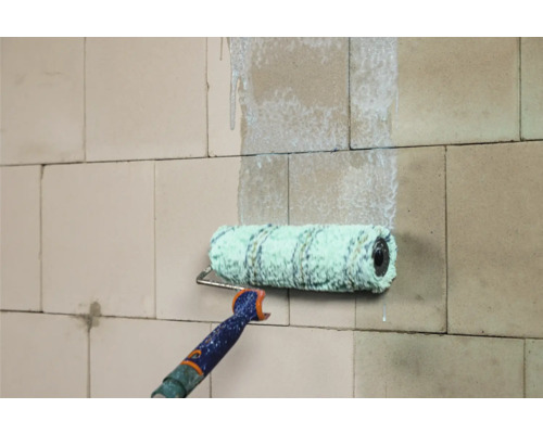 Verfroller die verf aanbrengt op een muur.