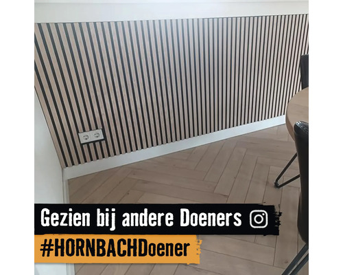 Wanddecoratie met houten panelen en visgraat parketvloer in een lichte ruimte.