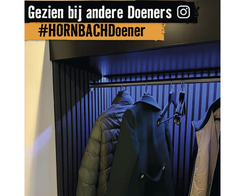 Moderne garderobe met jassen aan hangers onder indirecte verlichting