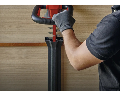 Bediening van een heggenschaar door een persoon met handschoenen.