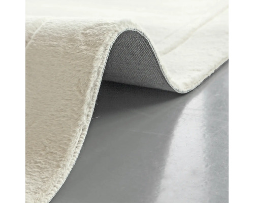 Detailopname van een lichtgekleurd vloerkleed met pool en rug