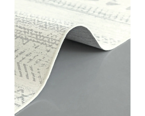 Detailopname van een lichtgekleurd tapijt met abstract patroon