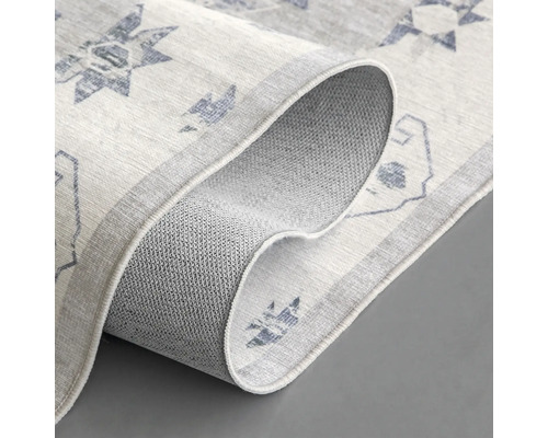 Detailopname van een vloerkleed met motief en antislip onderkant