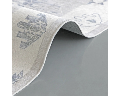 Detailopname van een lichtgekleurd tapijt met patroon