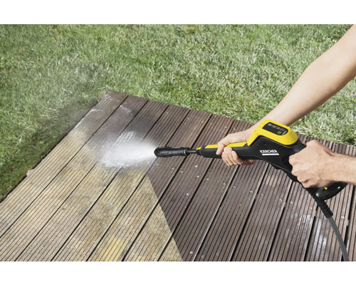 Persoon reinigt houten terras met Kärcher hogedrukreiniger
