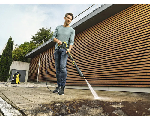 Man reinigt bestrating met een hogedrukreiniger buitenshuis.