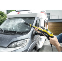 Een persoon reinigt een camper met een Kärcher hogedrukreiniger.
