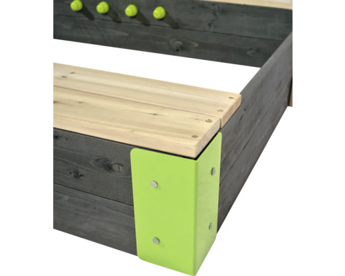 Detail van een houten zandbak met groene hoekstukken