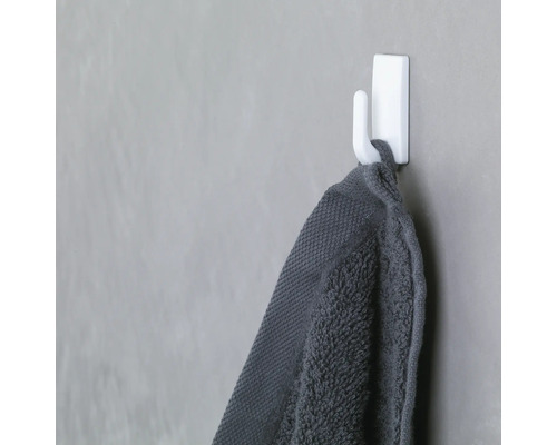 Grijze handdoek hangt aan een witte handdoekhaak